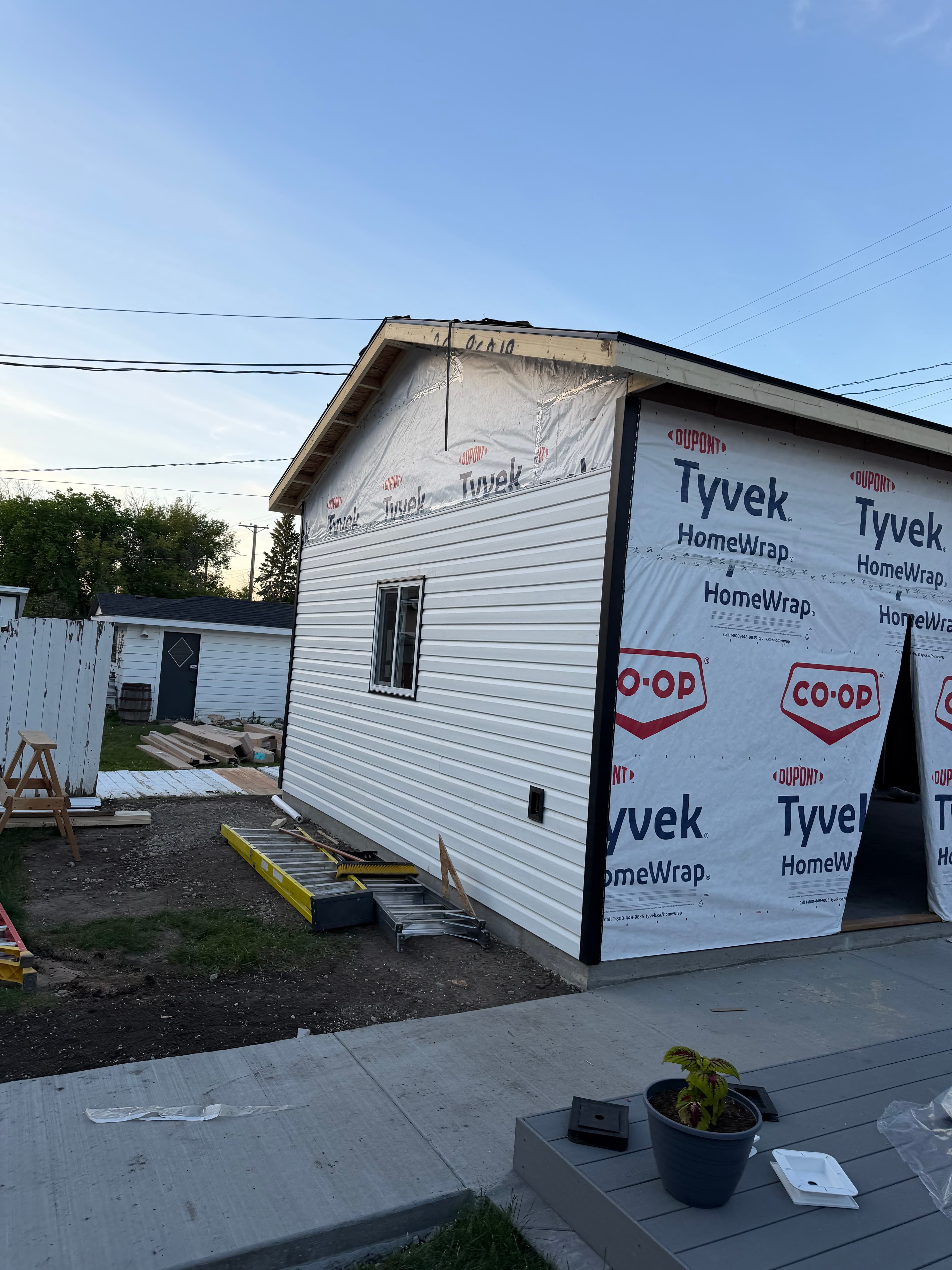 White vertical vinyl siding installation beginning on Saskatoon garage build